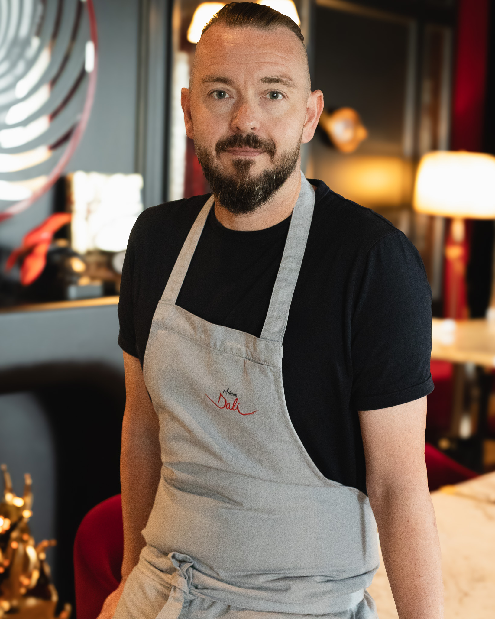 "Chef Tristin Farmer wearing Maison Dali apron, Experienced three-Michelin-star chef and founder of Chef's Canvas"