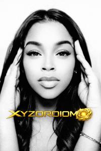 Black-and-white portrait of King Paradise, founder of XYZORDIOM, with gold logo overlay.