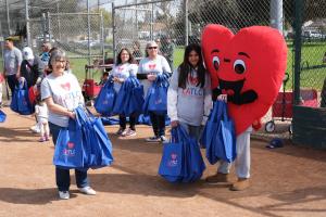Lissa Zanville, LATLC's Executive Director with volunteers and Lovey getting ready for their 10th anniversary with Bambino Buddy Ball at Heartwell Park in Long Beach, CA on March 7
