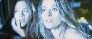 Kaitlin (Bonnie Jean Tyer) and Dani (Kelsey Christian) stare out the back of a car as lightning flashes and illuminates their faces