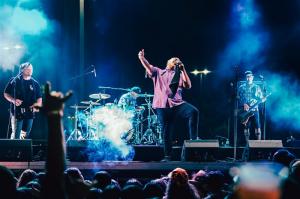 Reggae band The Green performing on stage with a crowd in front of them.