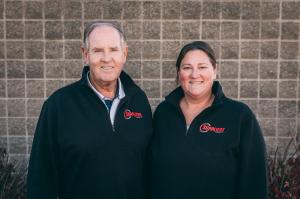 Doug Lorenz and Amy Sullivan of Suppliers Chemical standing side by side wearing black company jackets with the Suppliers Chemical logo.