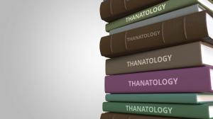 photo of books piled up with words Thanatology on the spines