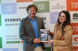 Winston Cowie presents the cover of his book kiwi to the Kingdoms: New Zealand to Blue Arabia at the Riyadh Writers Conference
