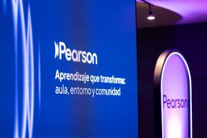 Pantalla azul con el logotipo de Pearson y el mensaje “Aprendizaje que transforma: aula, entorno y comunidad” durante un evento educativo en Ciudad de México