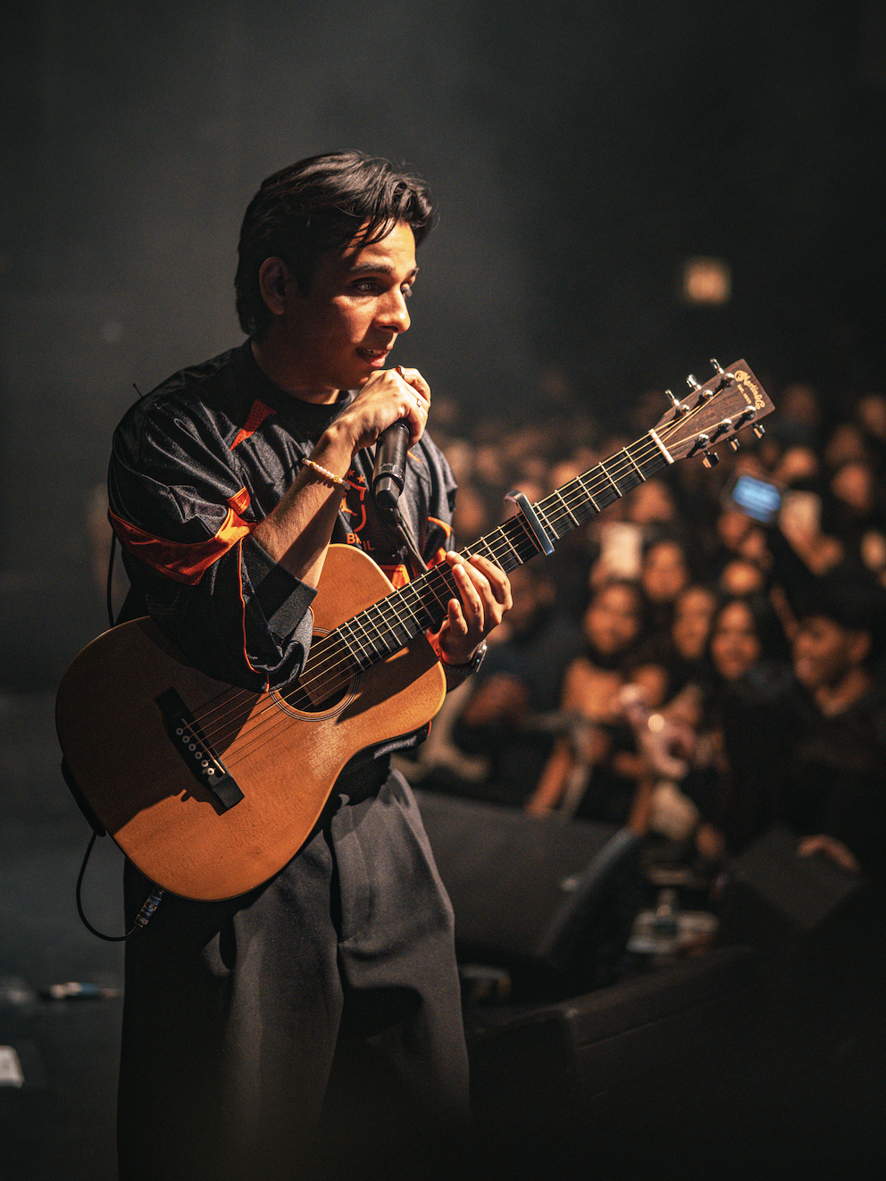 Close-up of Anuv Jain singing and playing acoustic guitar during a sold-out Chicago concert on the Dastakhat World Tour 2026 produced by Kash Patel Productions (Photo by Faaiz Ghouri)