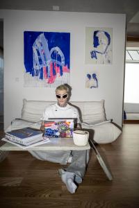 Designer Yannik Zamboni sitting on a couch in front of his laptop.