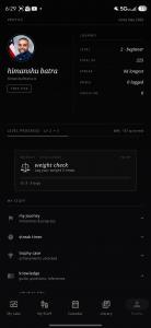 Screenshot of the redesigned My TRT App Android profile screen showing the journey ledger with level, XP, streak, and dose counts in cream serif type with ruled lines on a dark ink background.