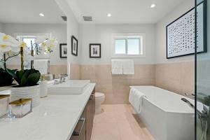 Walk-in shower conversion by Grand Renovations with modern tile and frameless glass.