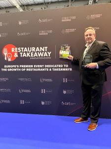 OiLChef CEO holding the new award in his hands with the london expo backdrop behind him