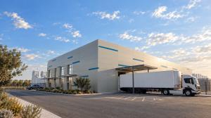 Side view of white data centre with blue flashes and an articulated lorry reversing into a loading bay