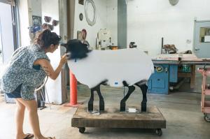Erika Huether adds the final details to a restored di Rosa sheep at Gordon Huether’s Napa studio. (Photo by Michael Cuffe)