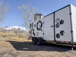 TORCH4, a white and enclosed trailer, installed at a closed landfill with mountains in the background