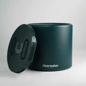 SnowCap thermoelectric and inflatable cold plunge tub by Clearwater Wellness Co., shown in a minimalist studio setting. The dark green/blue SnowCap lid is positioned upright beside the matching cylindrical tub, both branded with the Clearwater Wellness Co. logo.