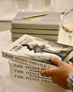 Elegant display of Park Avenue Firesale books next to a glass of rosé wine at exclusive Bergdorf Goodman book signing event