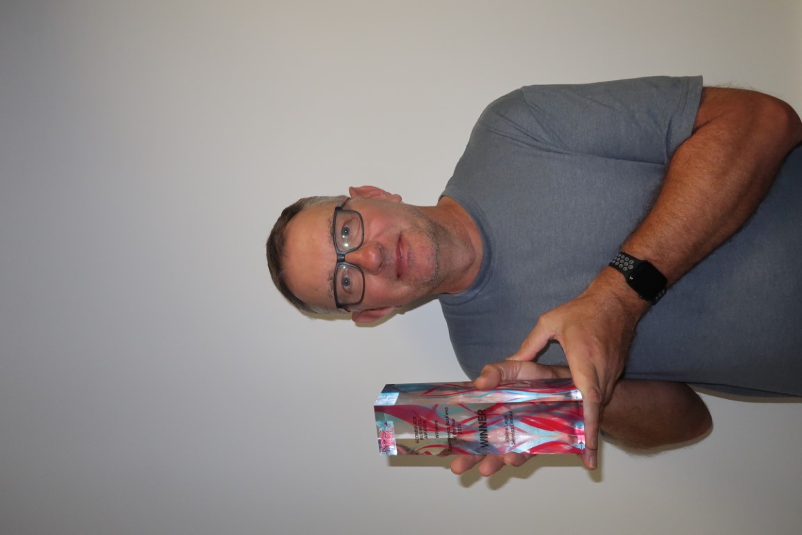 Mark Keenan holding award for best ecommerce business Wiltshire 2025