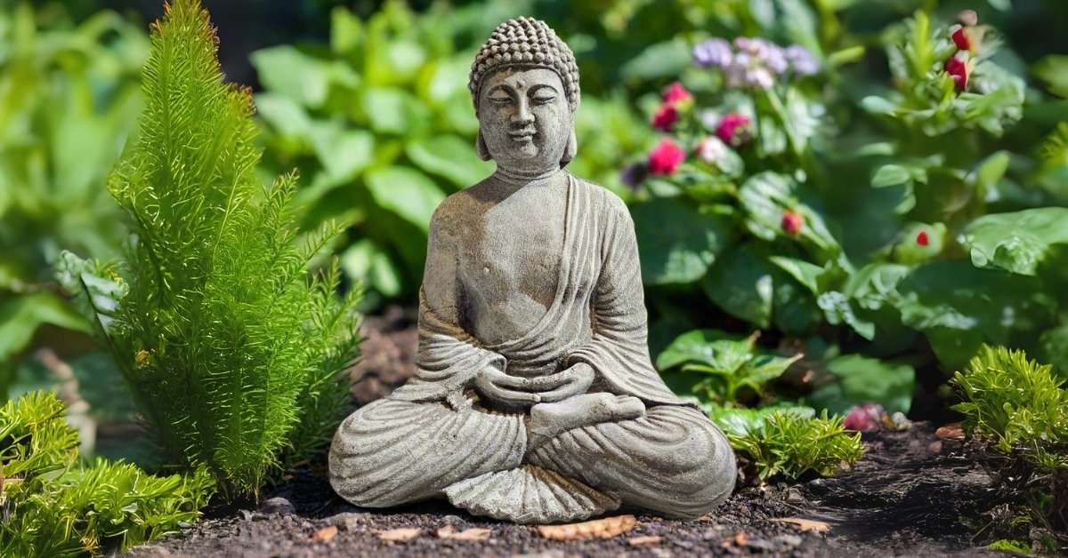 In New York’s Hudson Valley, Stone Grove Statuary is reviving centuries-old cast stone craftsmanship Handcrafted stone Buddha garden statue surrounded by flowers and greenery