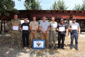 Five instructors of the National Police of Ukraine and two MAT Kosovo instructors display IMAS EOD certificates