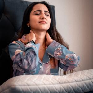 Lady waking up from deep sleep due to Neck pain
