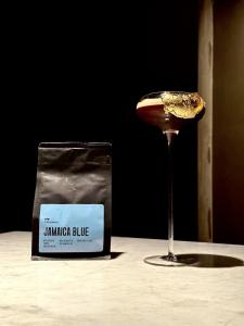 A long stemmed martini glass showcases a luxurious espresso martini served chilled with a gold wrapped black raspberry on the edge.