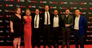 Professional photo of 7 team members of Real Estate Investment Finance (REIF), including Founder David Chehade and General Manager, Jake Sewell, standing in front of event background with The Advisor Awards and National Australia Bank logos on a black bac